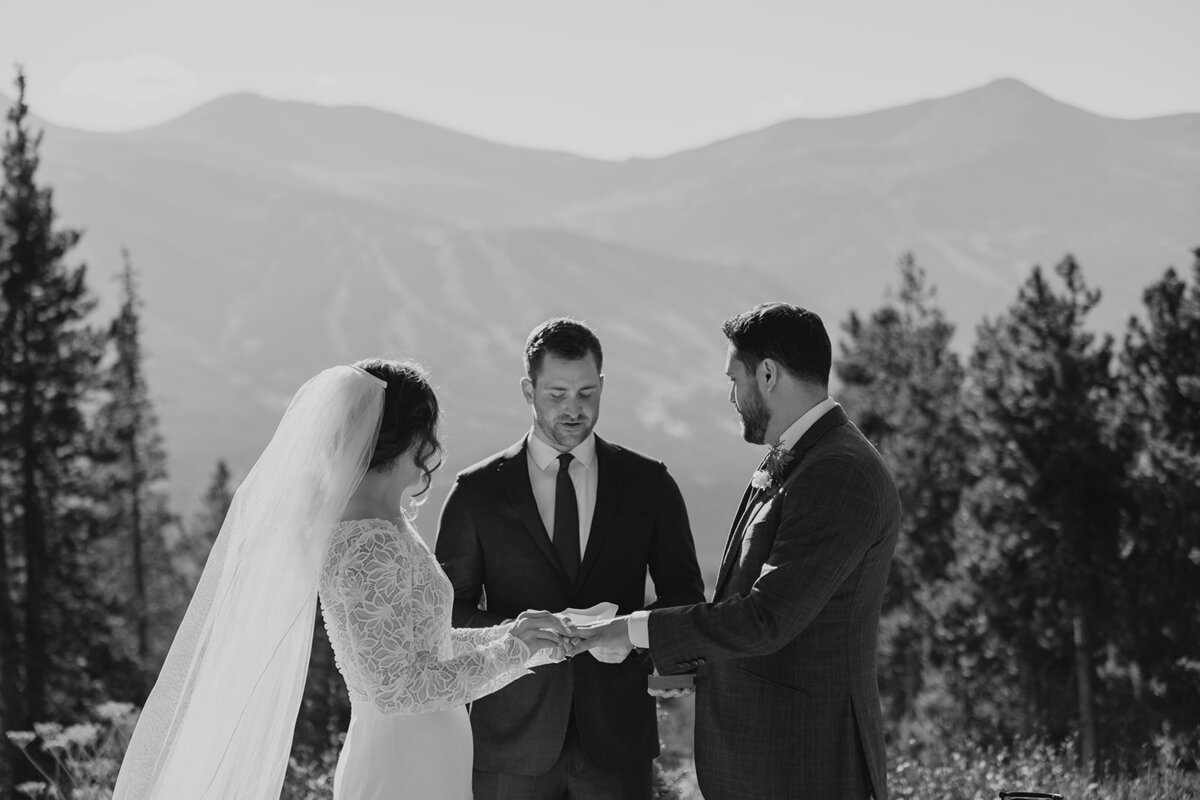 photo of bride and groom sharing vows with Breckenridge in the background