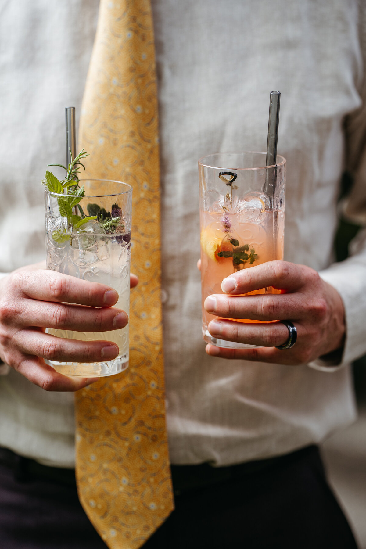 Two wedding cocktails garnished with herbs