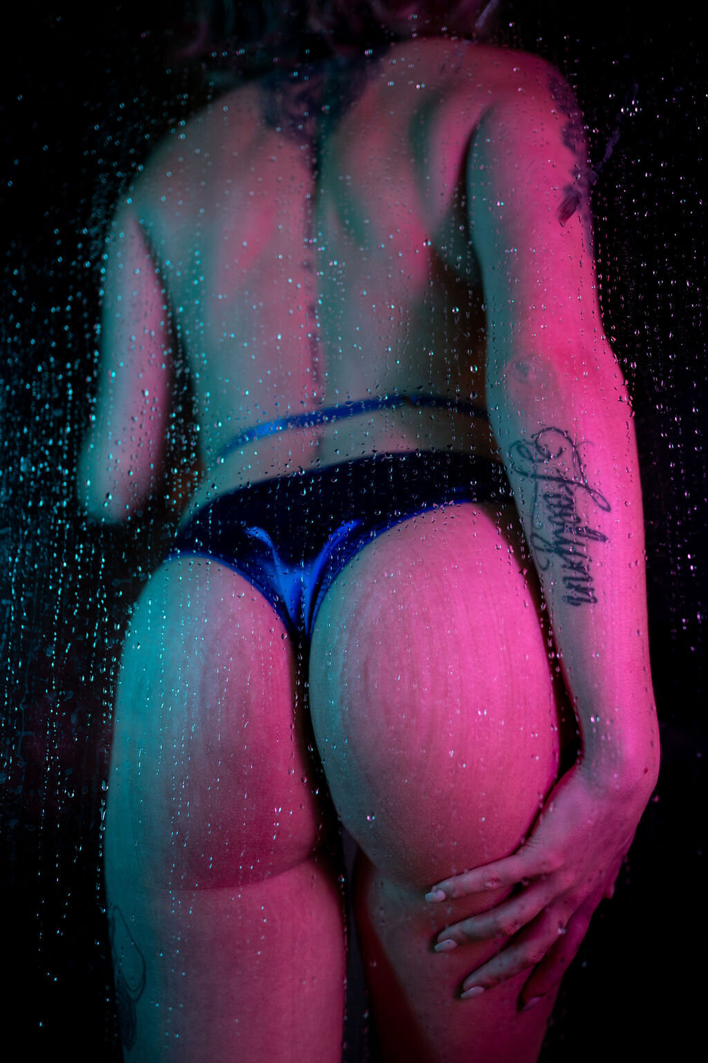 boudoir image of woman in shower with butt showing and blue lingerie