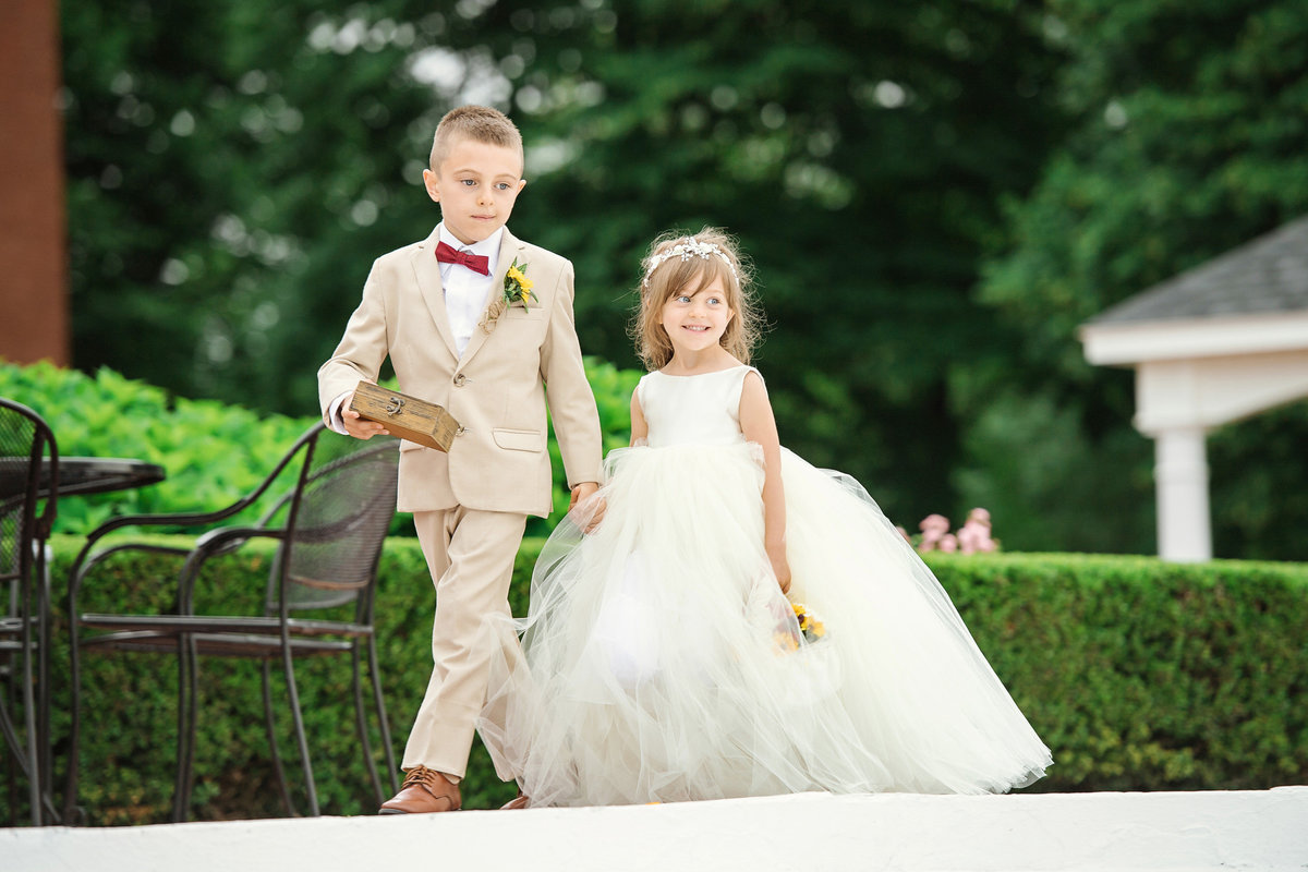 Ring bearer and flower girl walking down the aisle at The Bourne Mansion