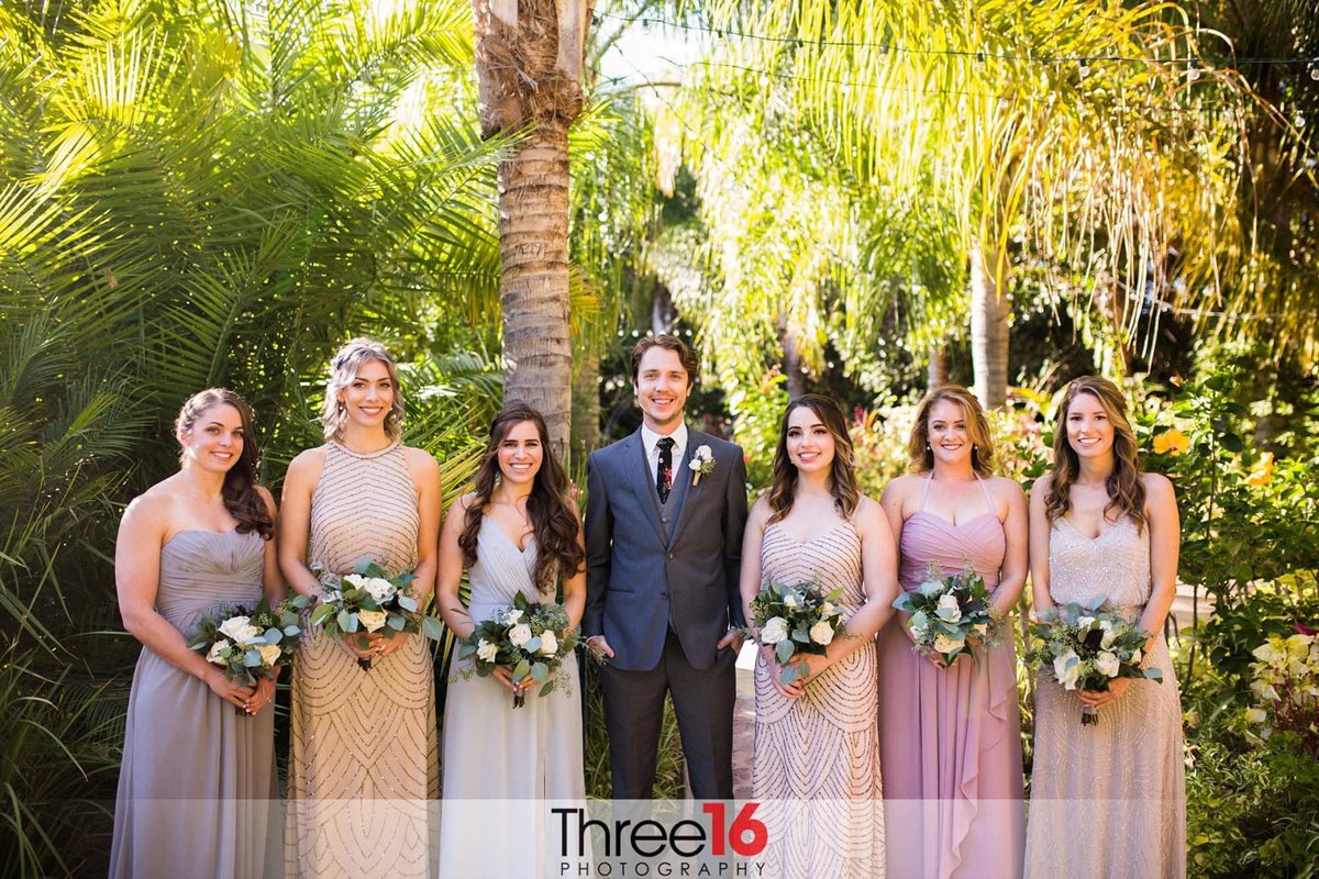 Groom poses with the Bridesmaids