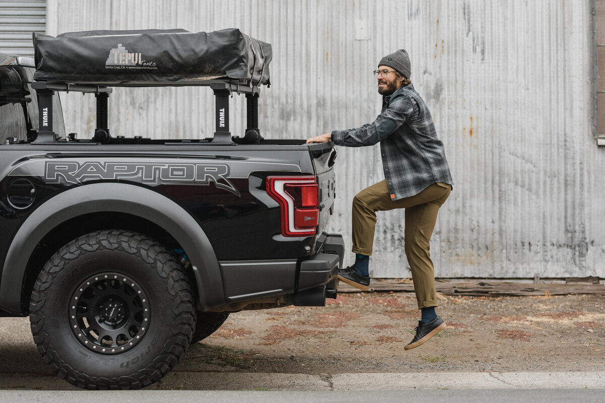 man getting on truck bed at brand photoshoot