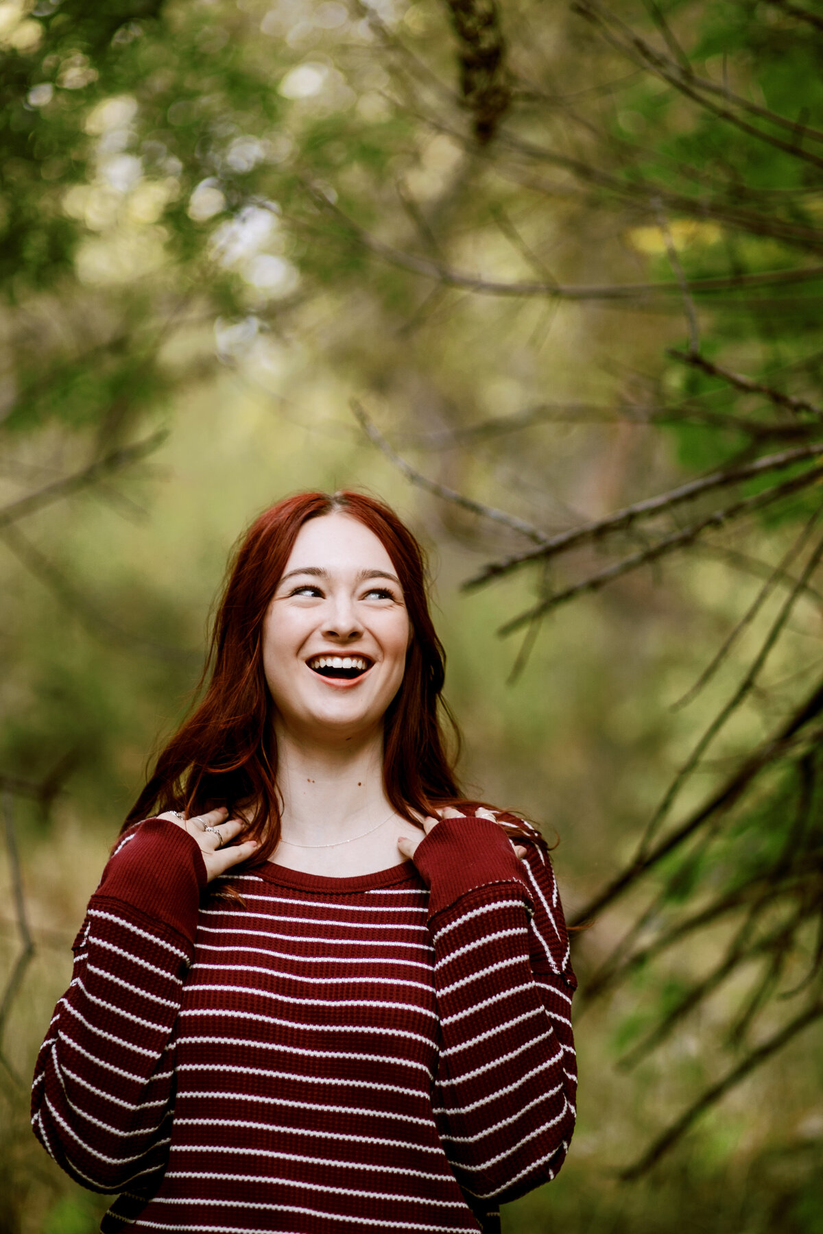 Colorado Senior Photo of laughing teen with red hair in woods