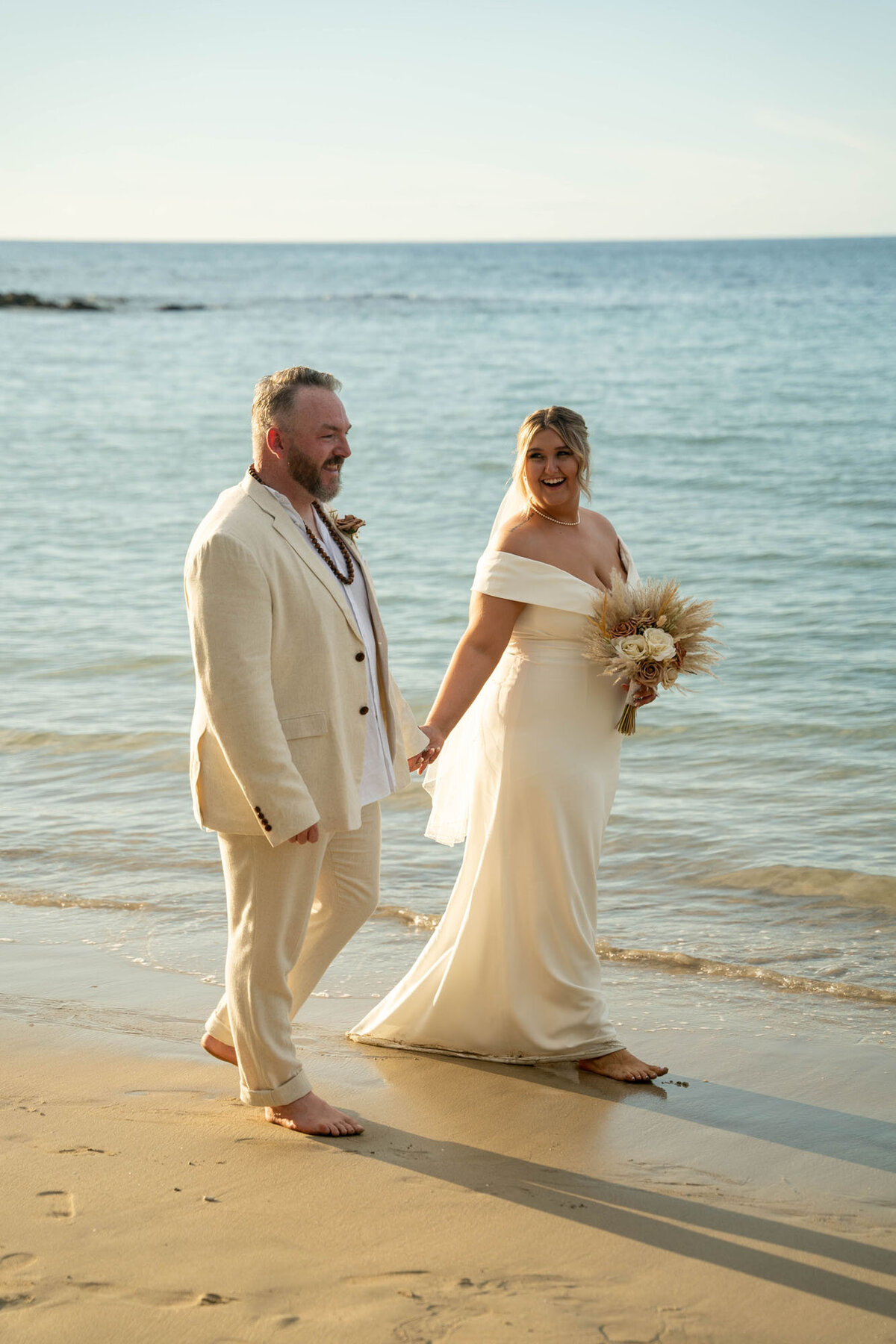 Bride and groom walking across beach for elopement photography on Big Island with Hawaii Adventure Portraits