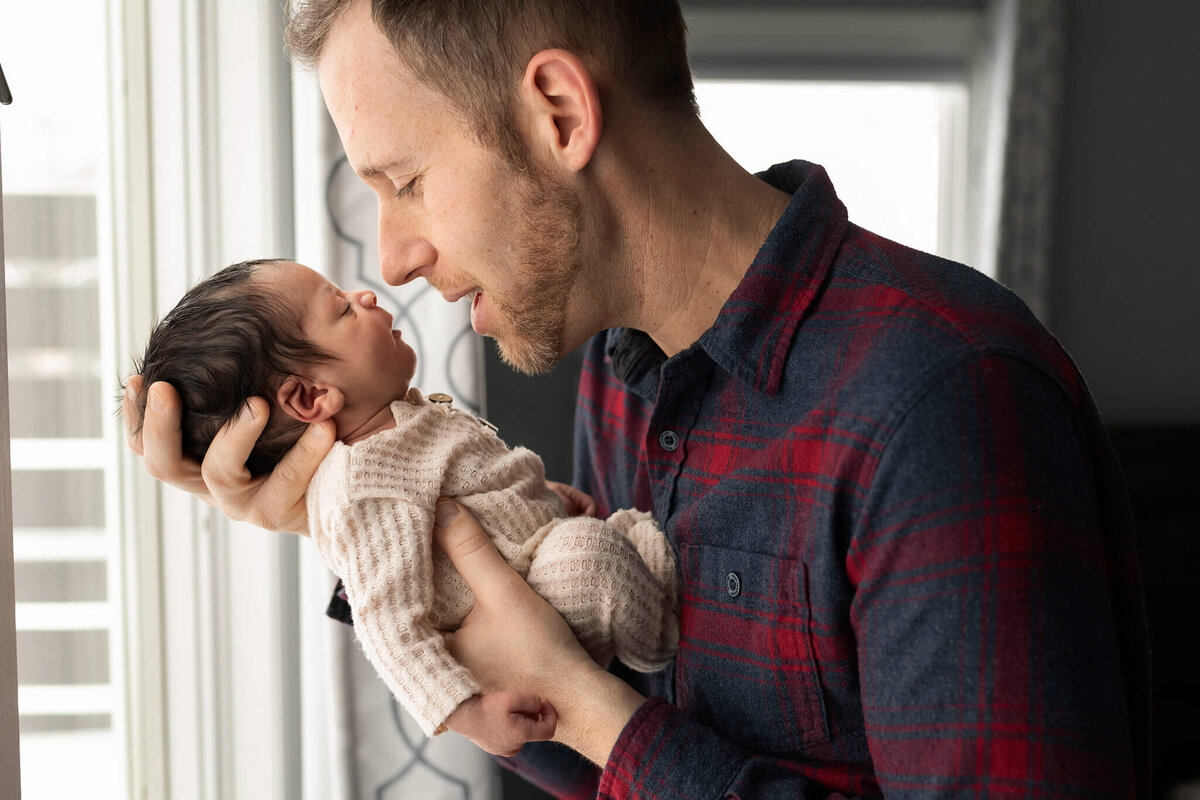 NJ Newborn Photographer poses dad holding his baby close