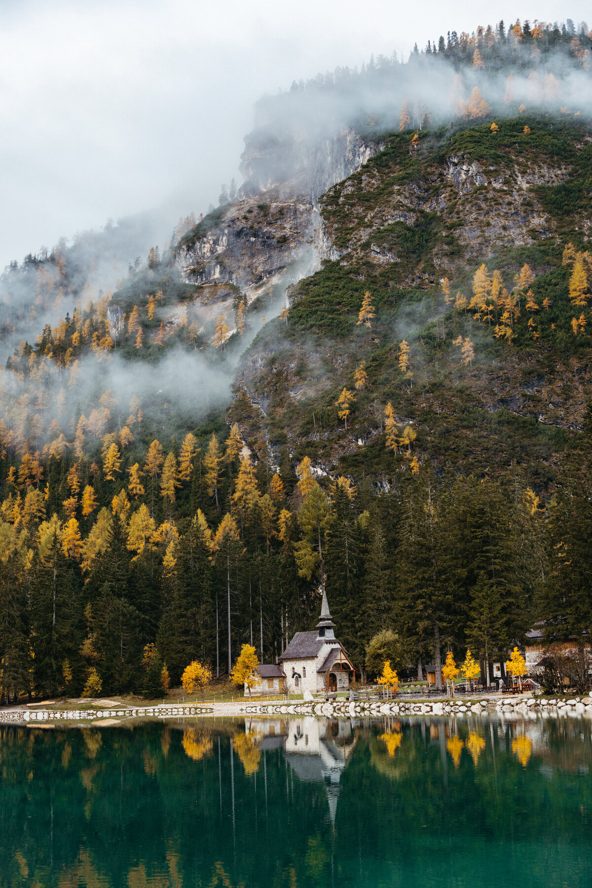 Chapel by Lago di Braies surrounded by fall colors