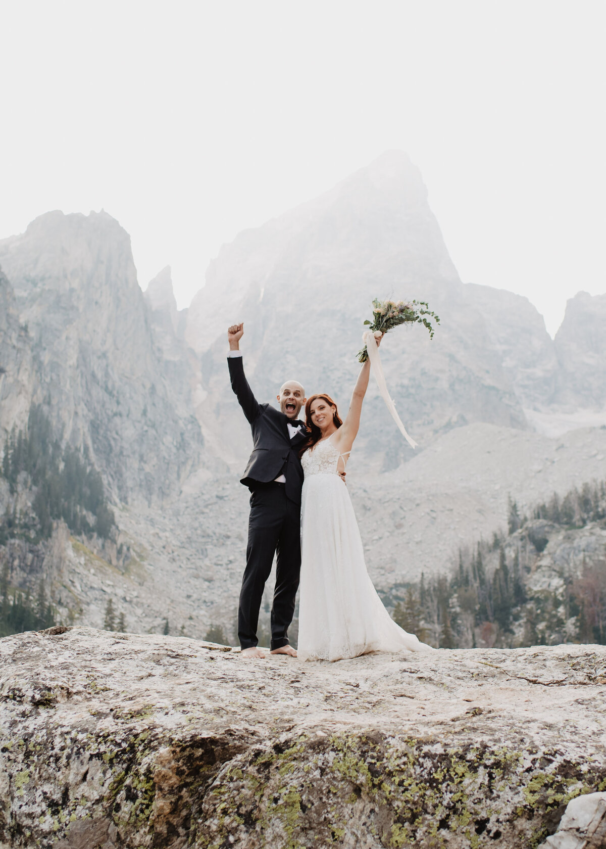Jackson Hole photographers capture man and woman with arms in air