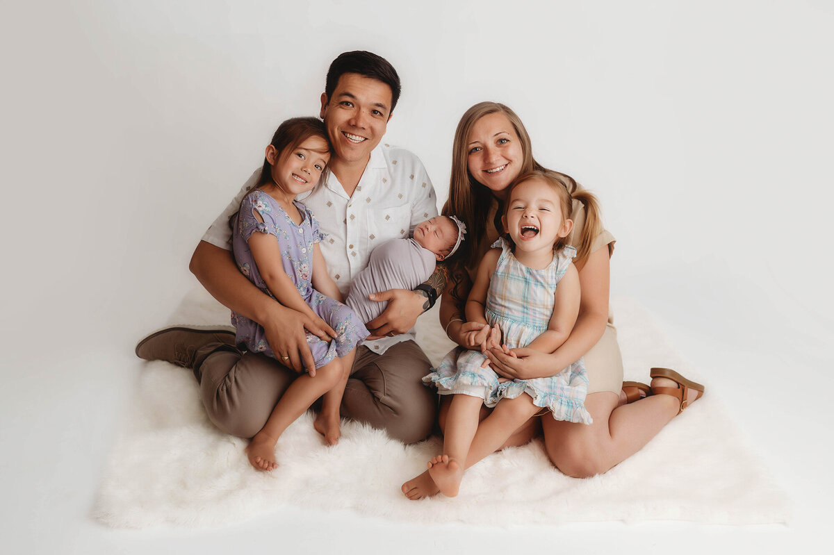 Family embraces their infant during Newborn Photos in Charleston, SC.