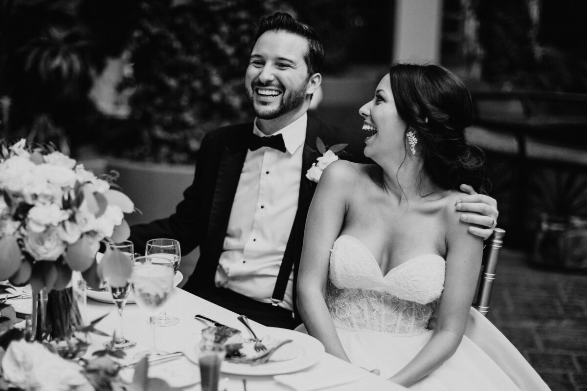 bride and groom laughing during toasts at reception