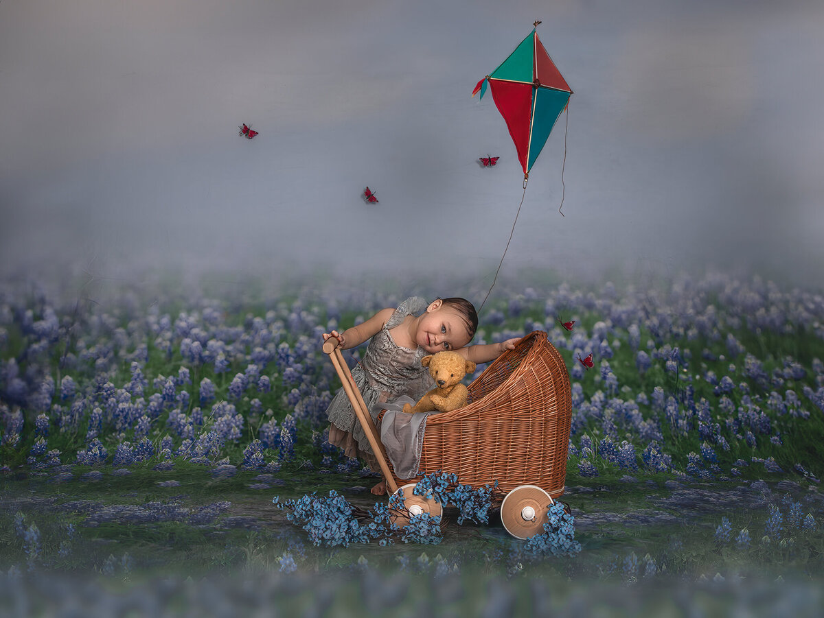 One-year-old baby in whimsical floral setting with toy stroller and kite – Milestone photography session in Ottawa