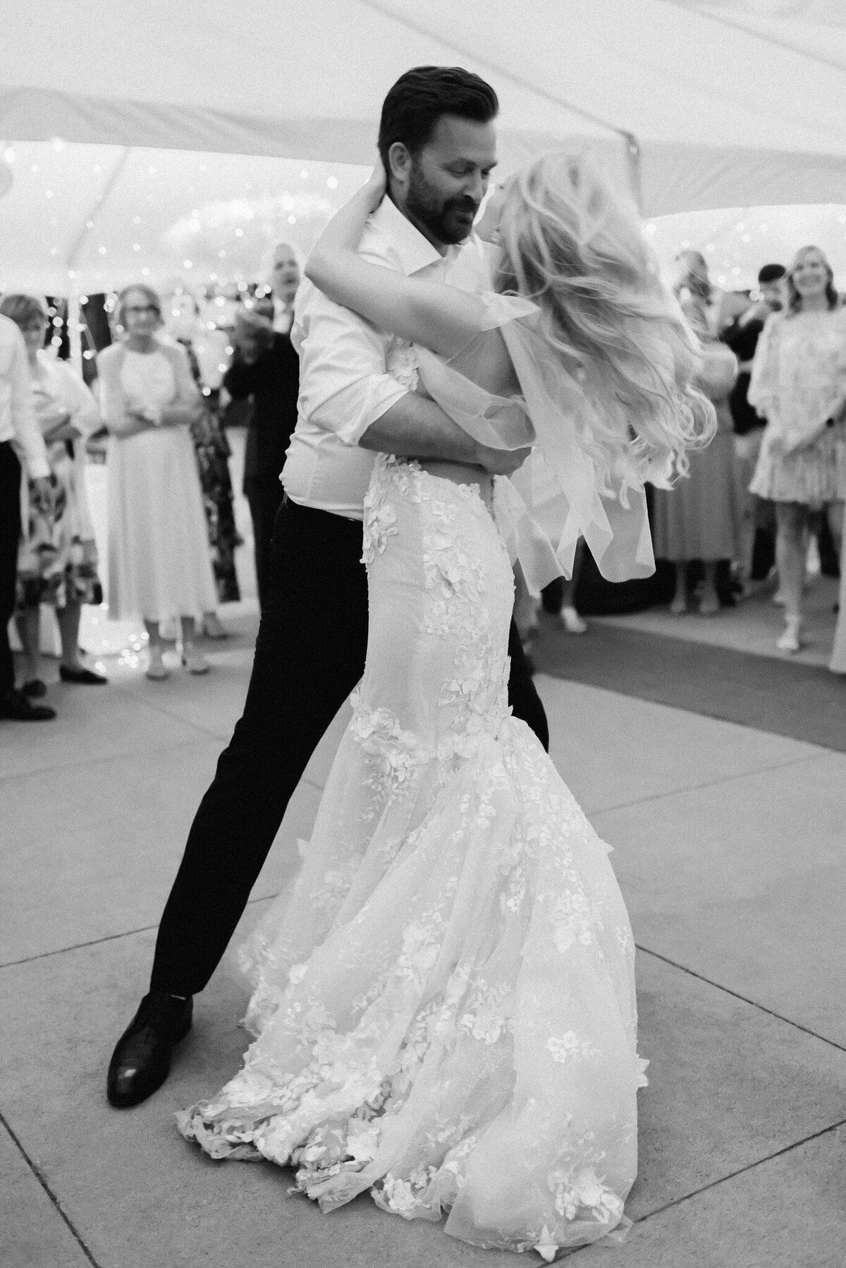 Black and white image of bride and groom dancing at wedding reception by Kaity Body Photography, elegant film inspired wedding photographer in Calgary, Alberta. Featured on the Bronte Bride Vendor Guide.