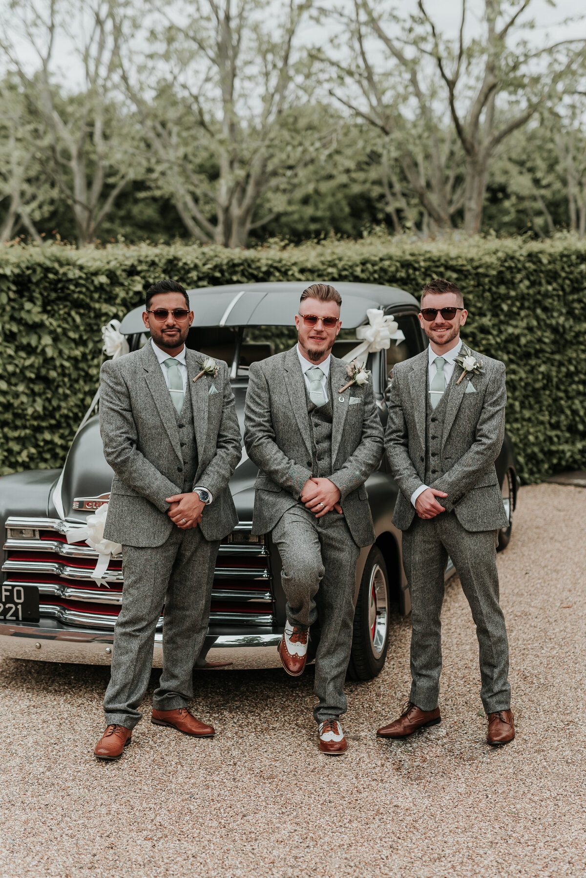 Grrom and his Groomsmen pose in front of his retro chevrolet pick up at a fun spring wedding at Bury Court Barn, Farnham