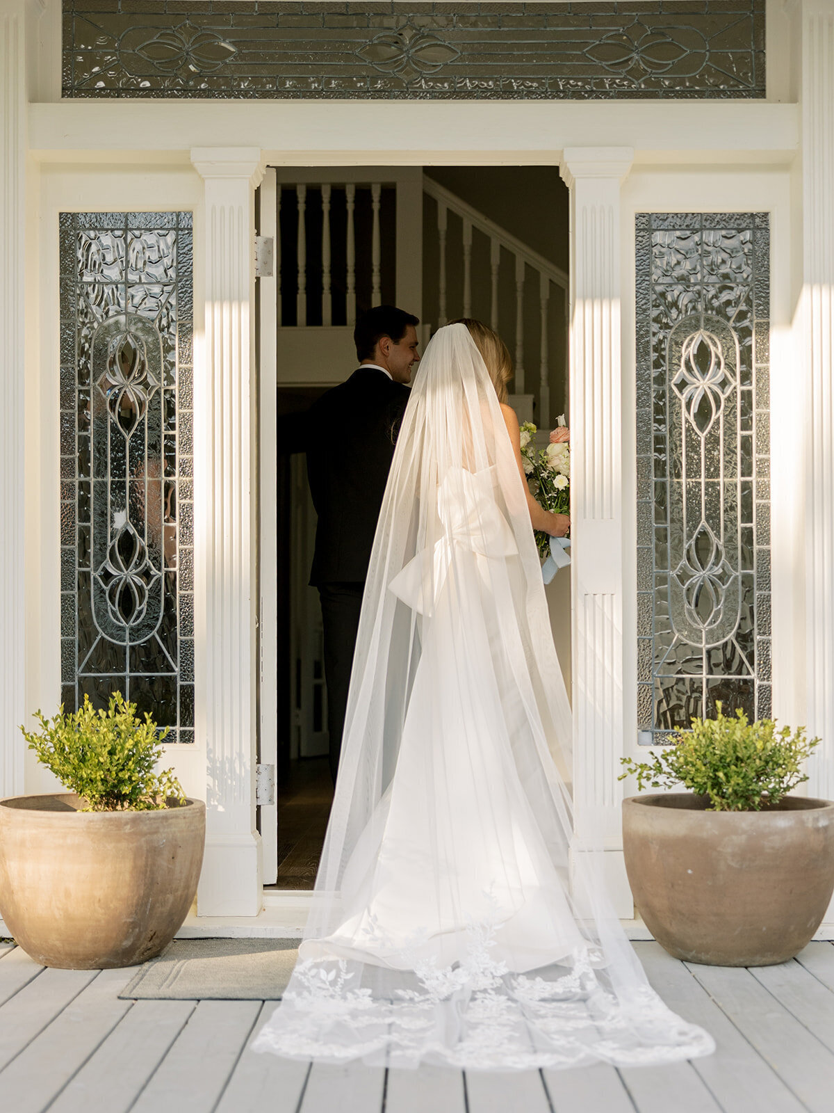 Bride in the front doorway of The Grand Lady's 1881 mansion for bridal portraits