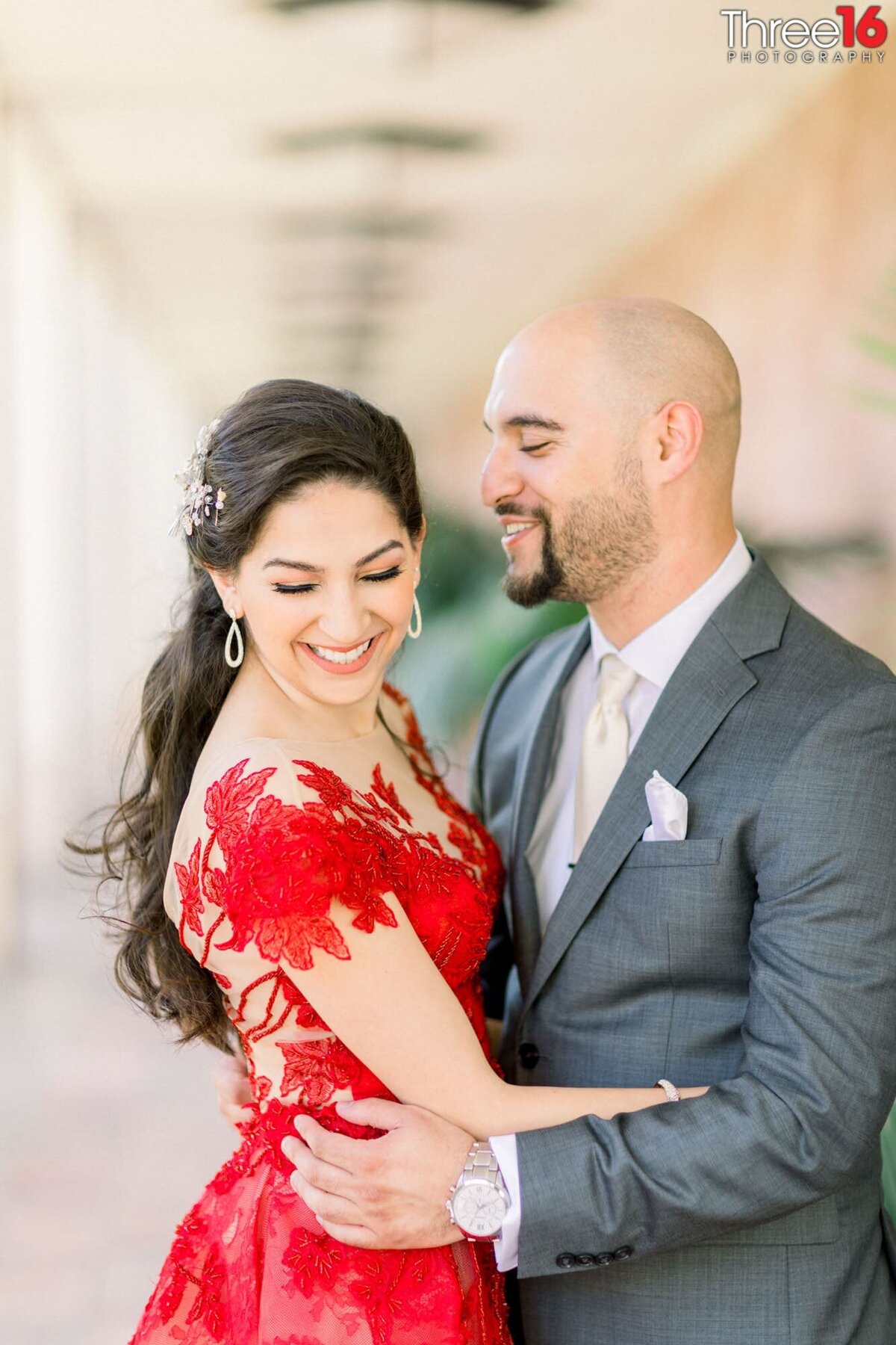 Groom to be makes his Bride laugh while embracing each other