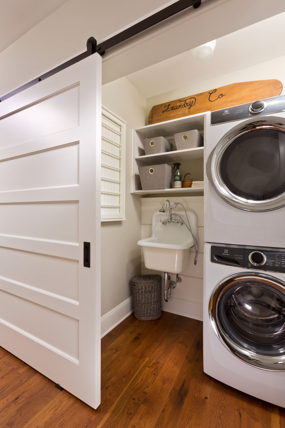 laundry room with stack washer dryer and barn door