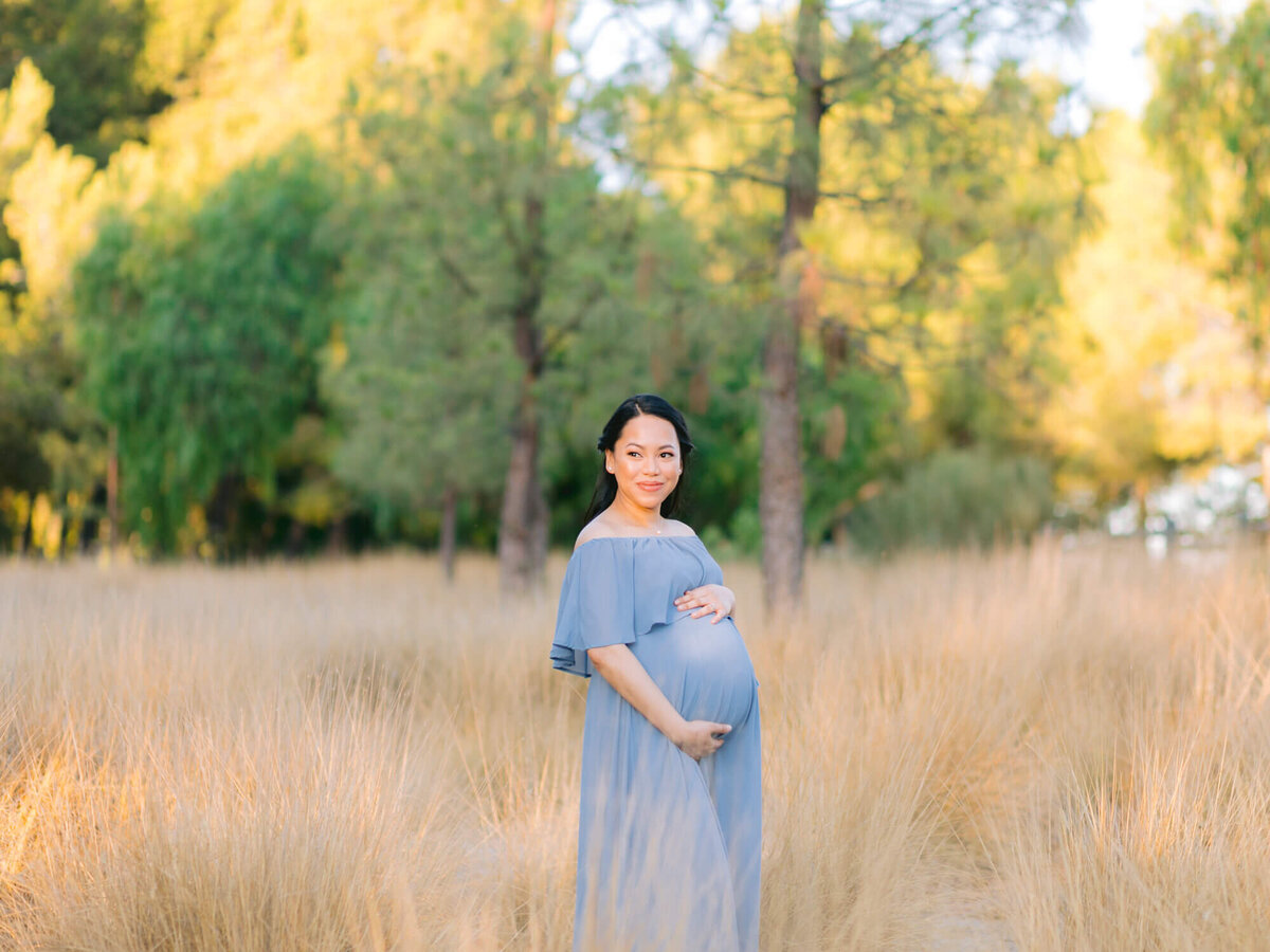 sunset maternity portrait wearing blue flowy dress at yellow brown grass field in yorba linda
