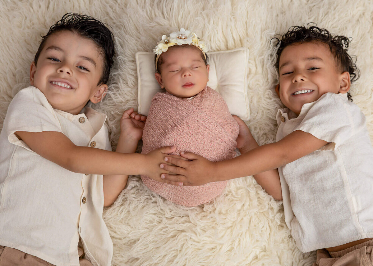 Siblings smiling on soft carpet near Seguin