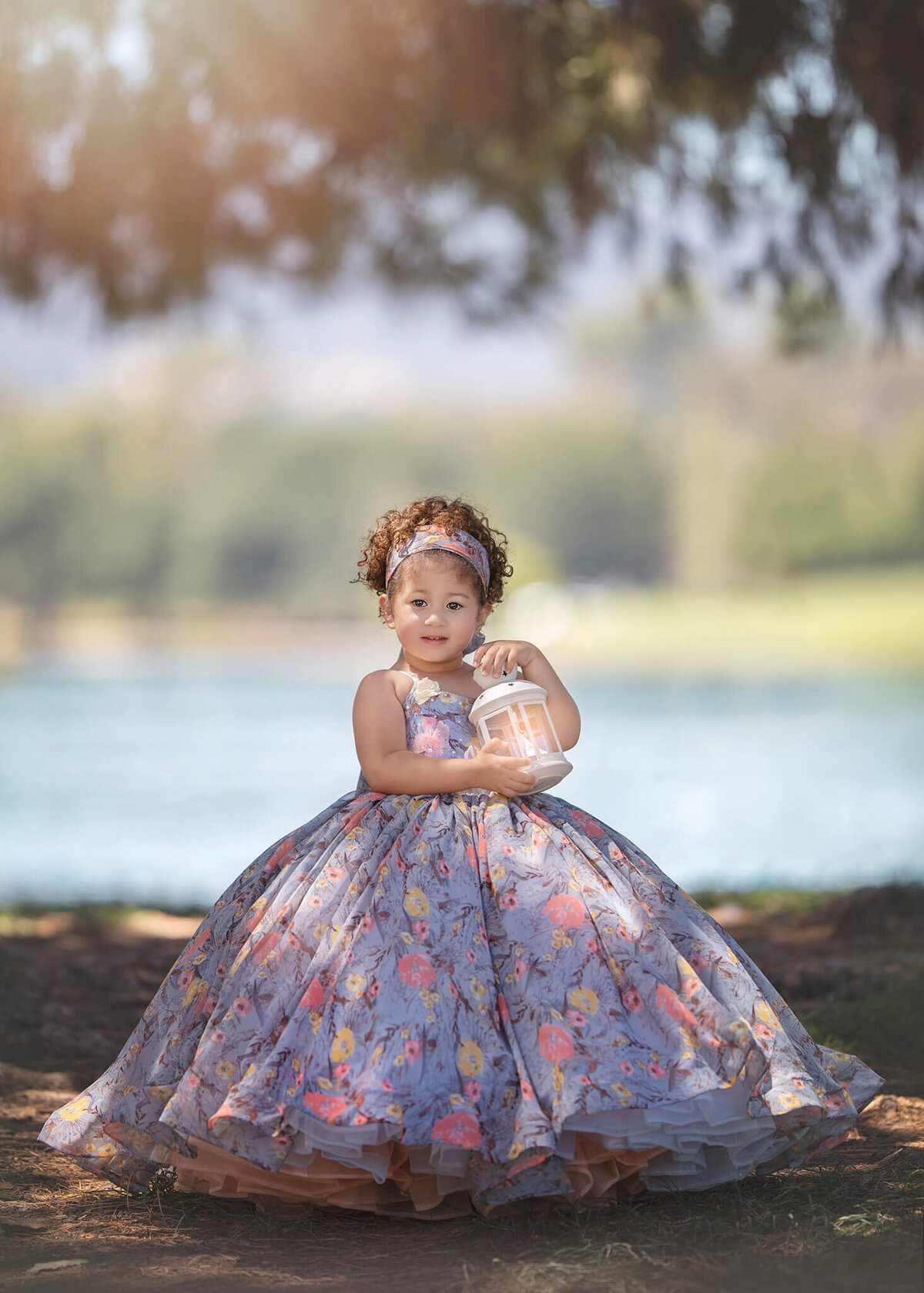 Girl wearing a couture gown and holding a lantern atpark in Encino