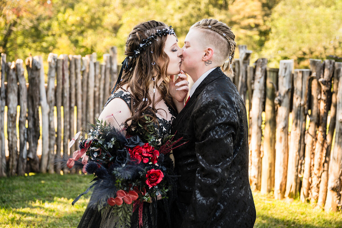 Two queer brides kiss following their first look in the backyard of an Airbnb they rented for their elopement day in Roanoke, Virginia.