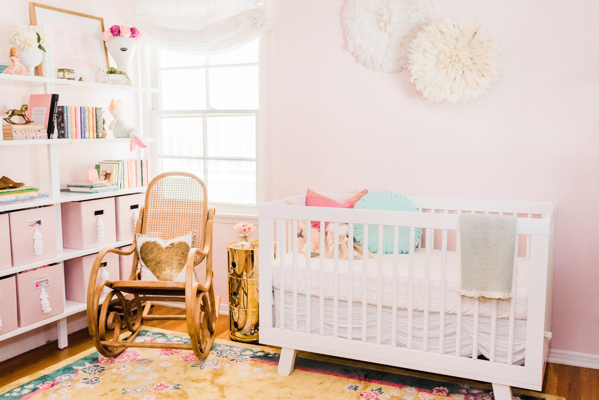 Modern Deco nursery with floral art deco rug and pink walls
