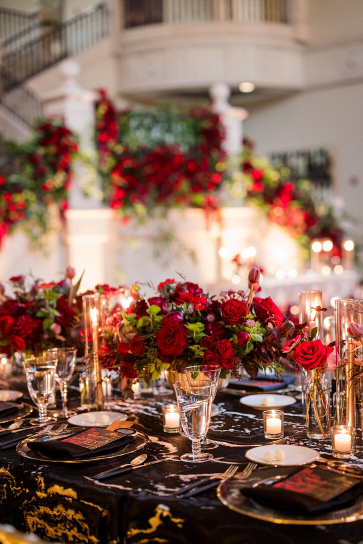 kings tables, black and gold accents, red flowers, red roses, taper candles, staircase flowers