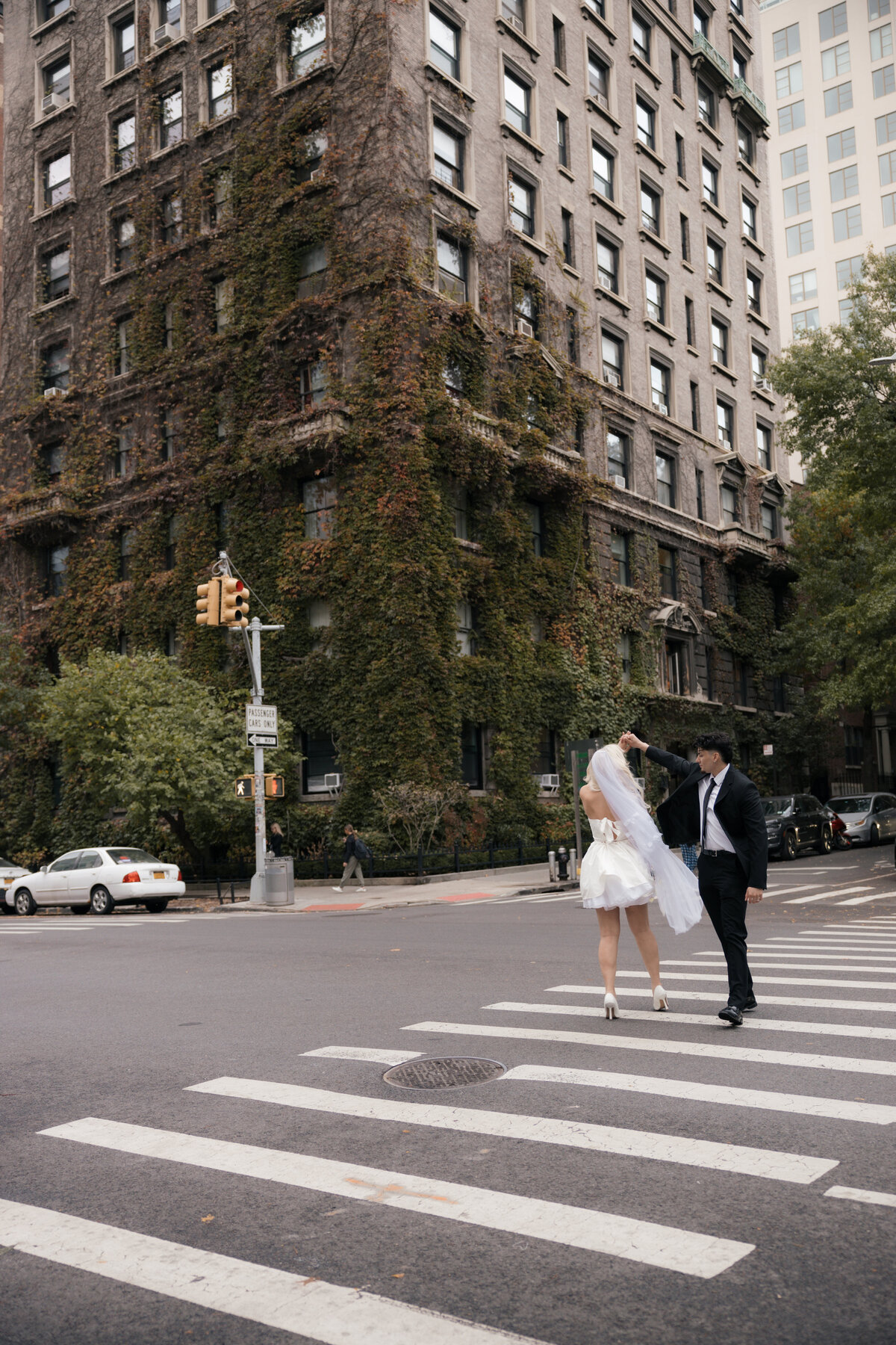 Elopement couple strolling through NYC streets with the skyline in the background.