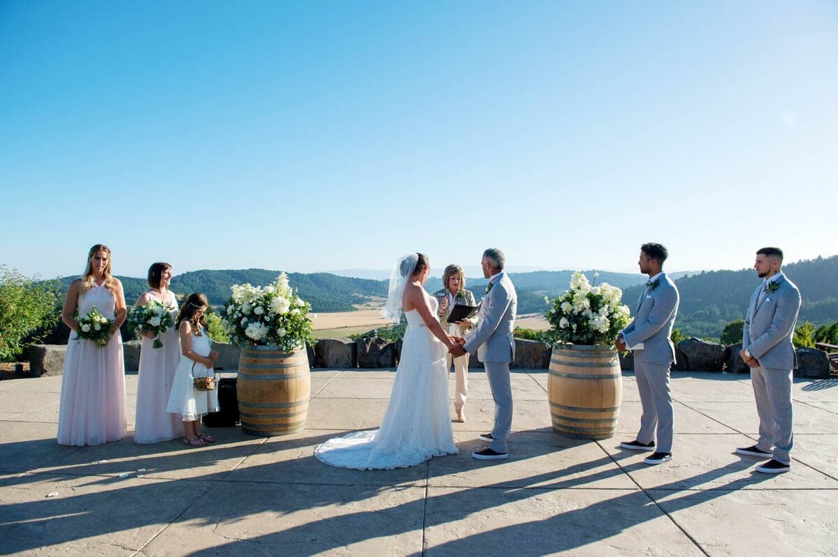 a wedding ceremony takes place overlooking oregon wine country valley