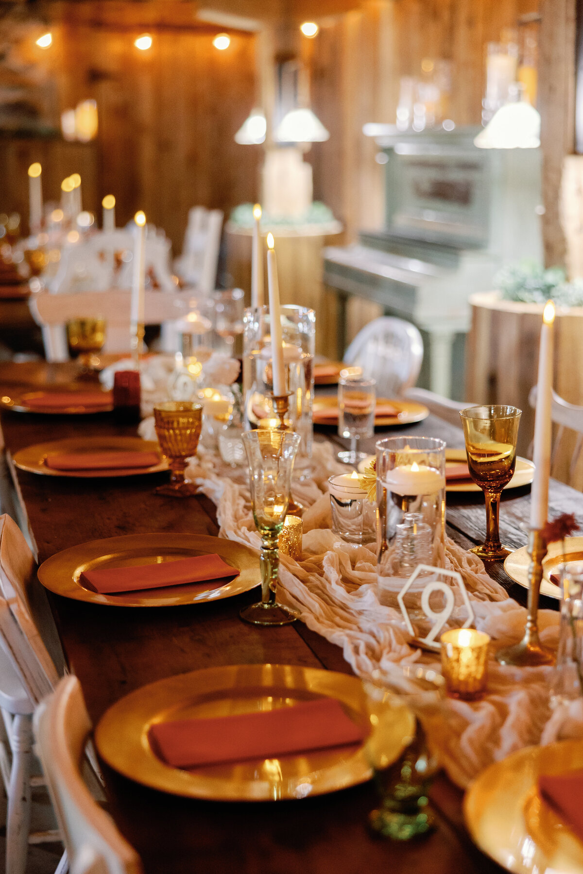 Maryland wedding reception with long farmhouse tables decorated with amber plates, candles, and elegant florals.