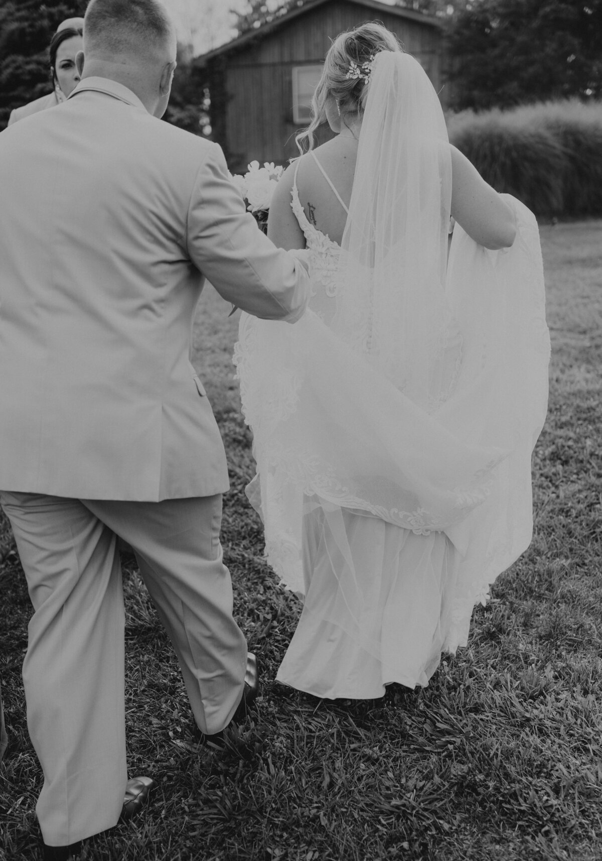 groom holding brides dress during wedding day