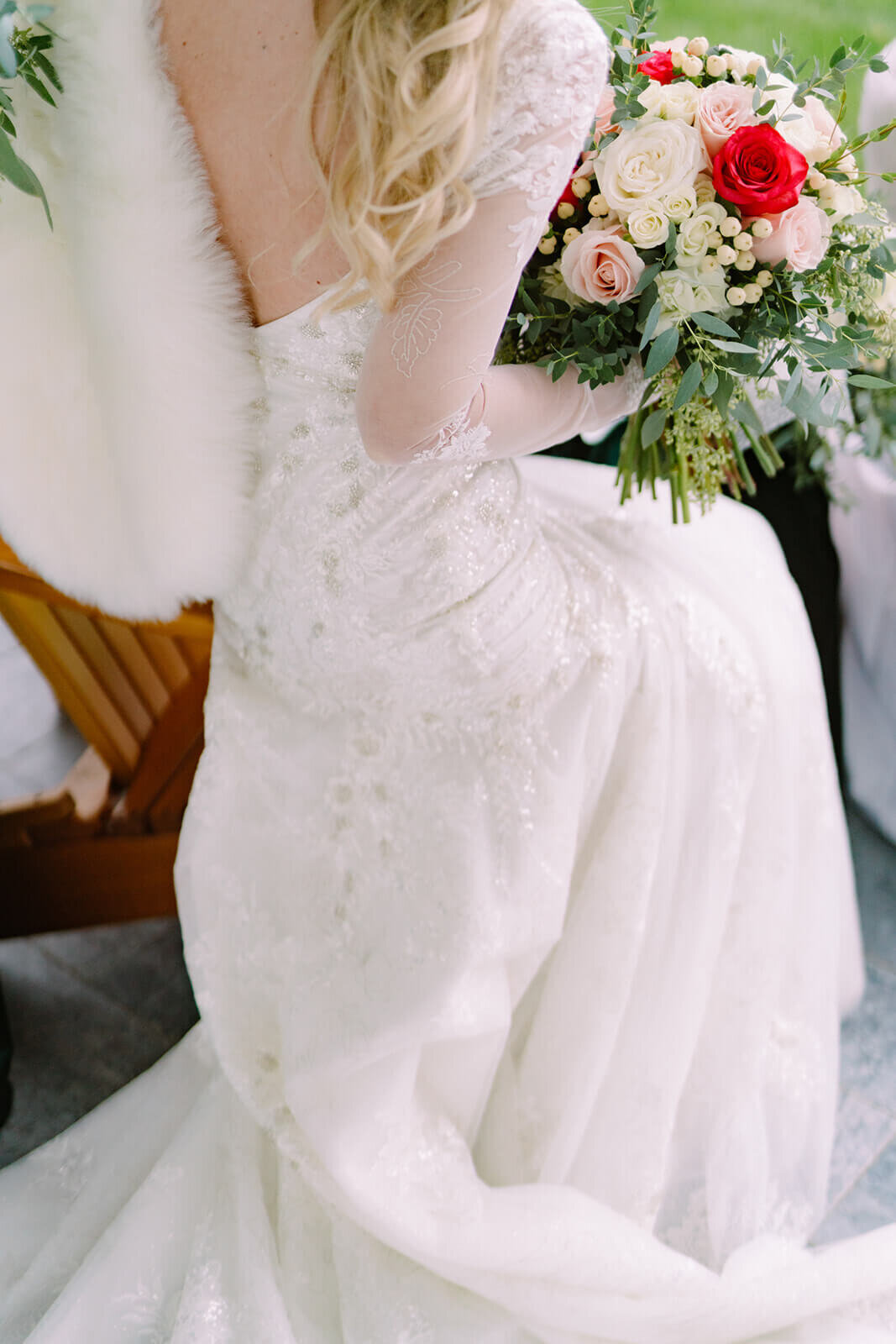 Bride sitting down holding bouquet of bright florals