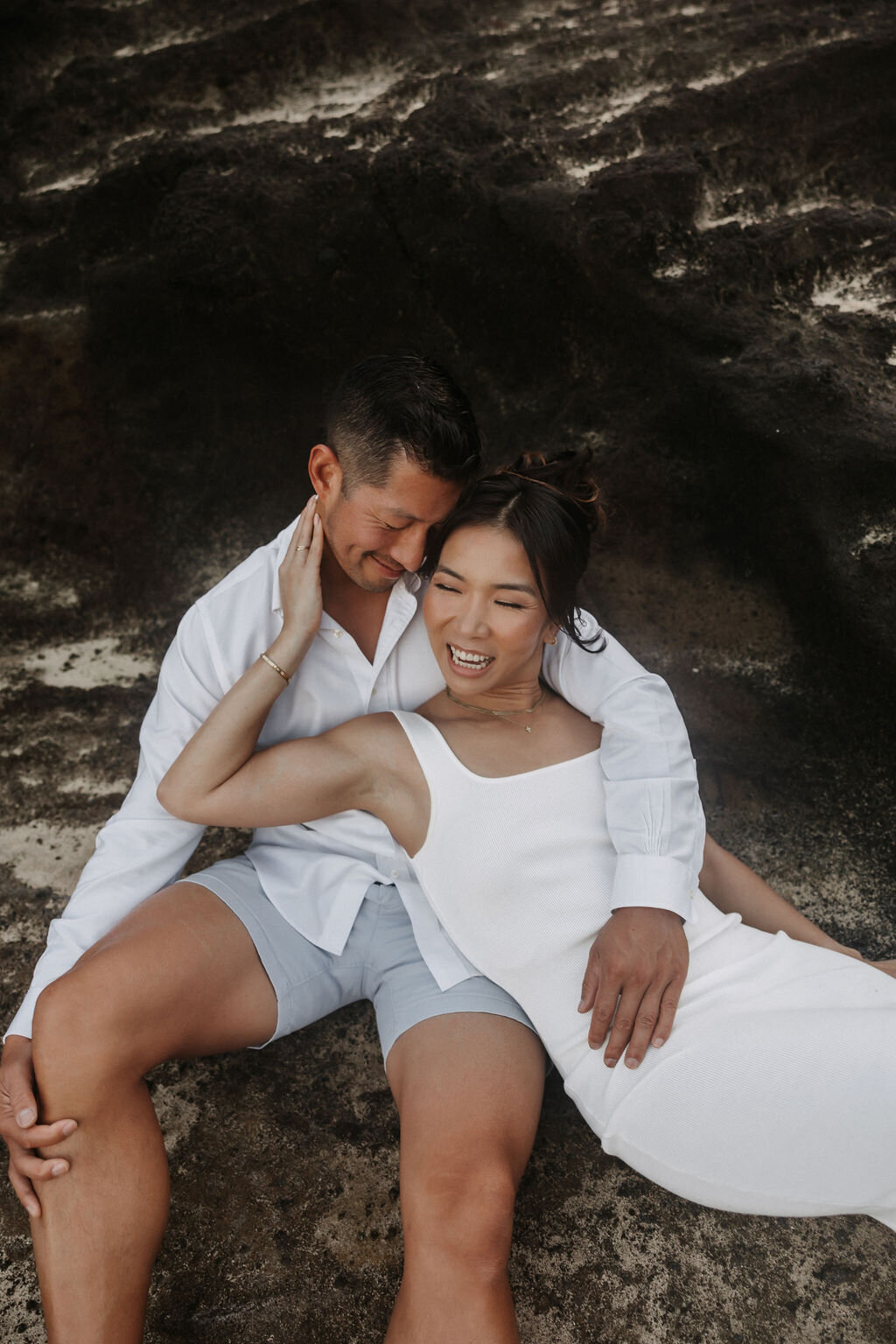 Couple posing reclining on the rocks at holana blowhole on oahu