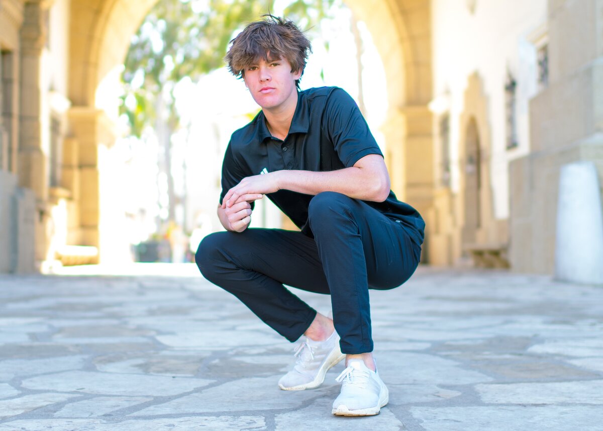 senior boy posing for senior photos in santa barbara ca at the courthouse