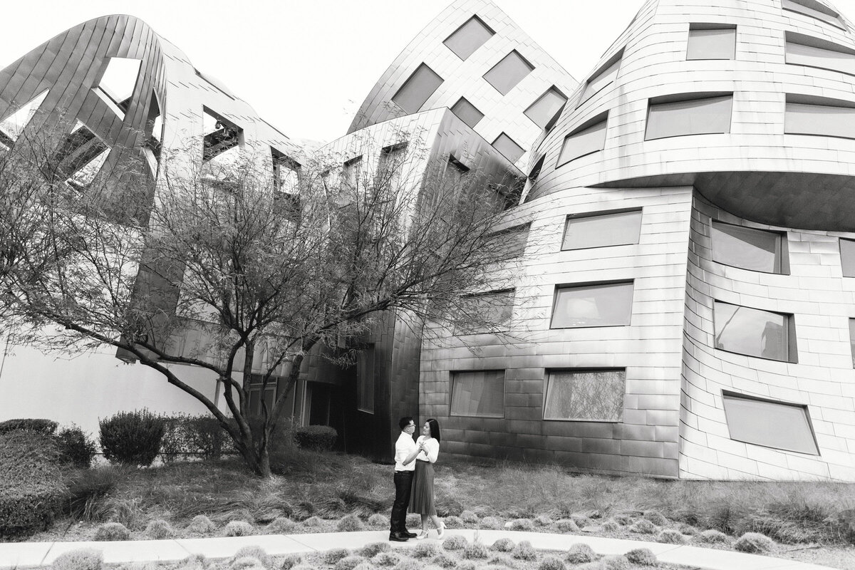 Engagement portrait of a couple by a unique, contemporary building with bold architectural details in Las Vegas
