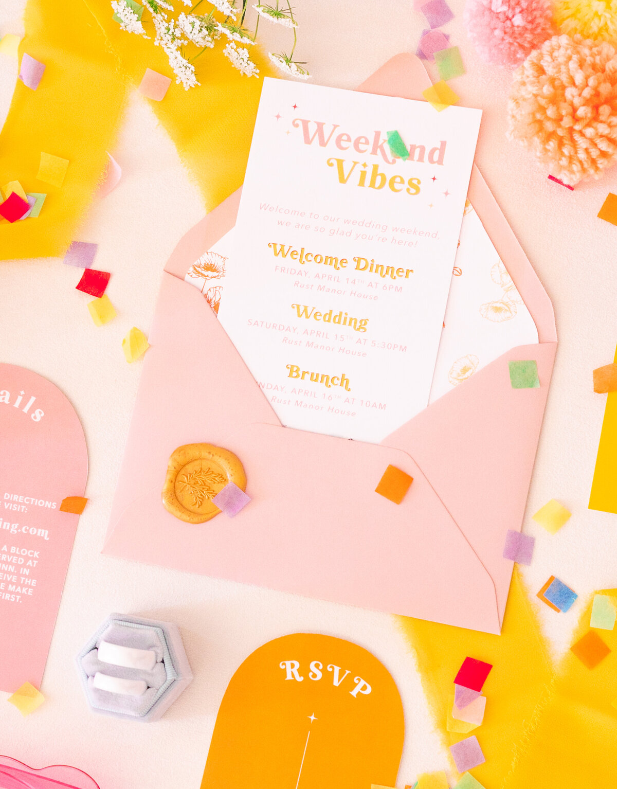 colorful wedding invitation and confetti with white stone wedding rings by amanda richardson photography