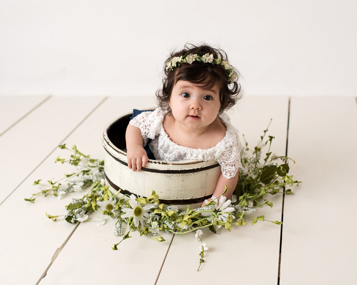 Lovely baby in a flowery bucket and flower headdress photoshoot in Houston