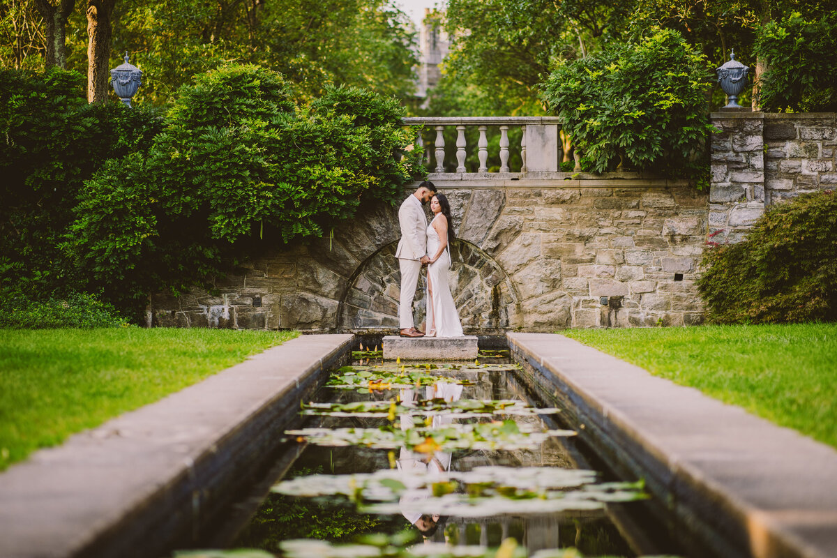 Engaged couple standing over a pond at the New Jersey Botanical Garden in Ringwood