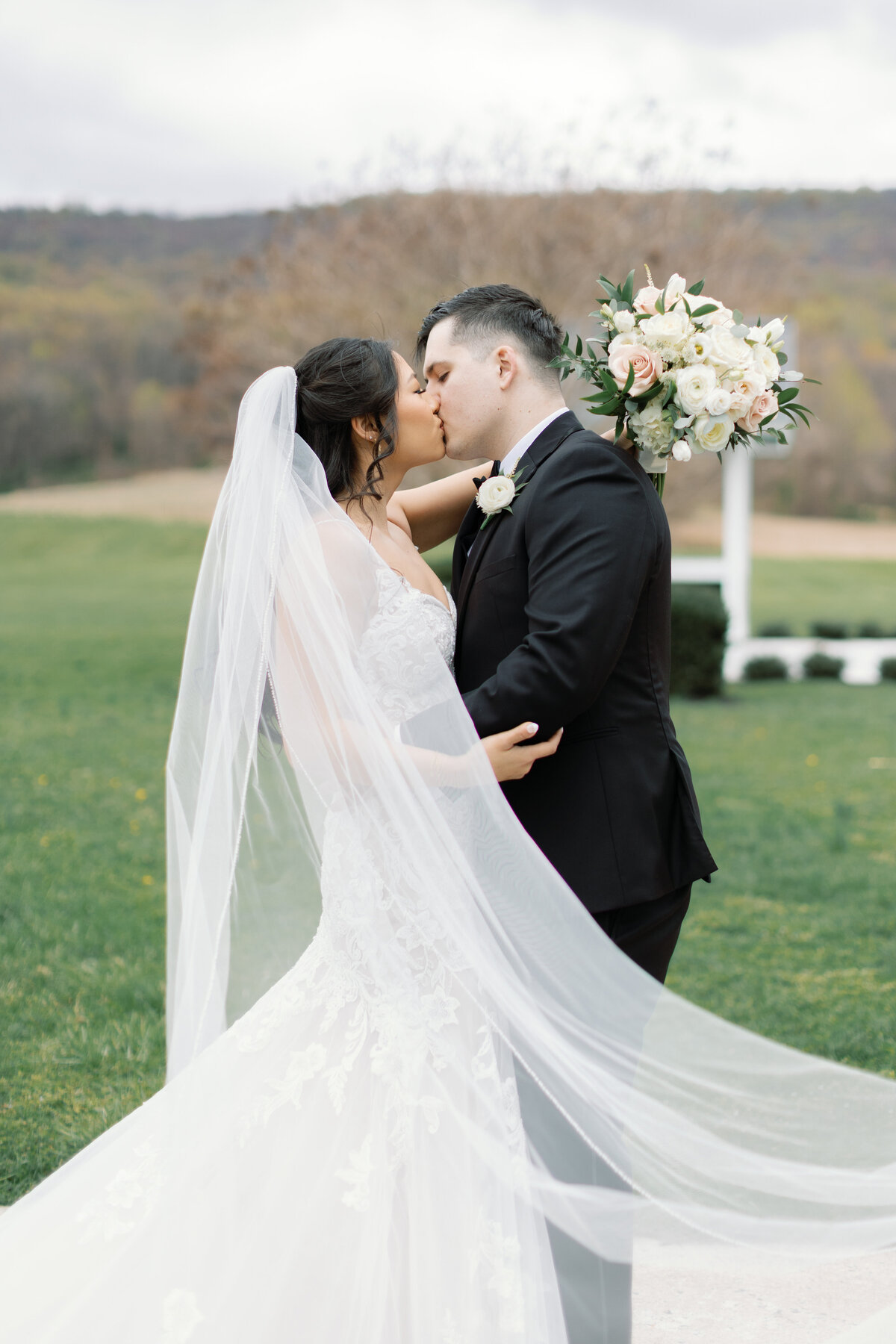 ouple kissing in front of mountain backdrop during outdoor ceremony at Springfield Manor in Maryland.