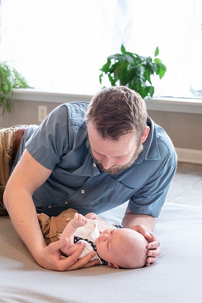 dad playing with newborn boy