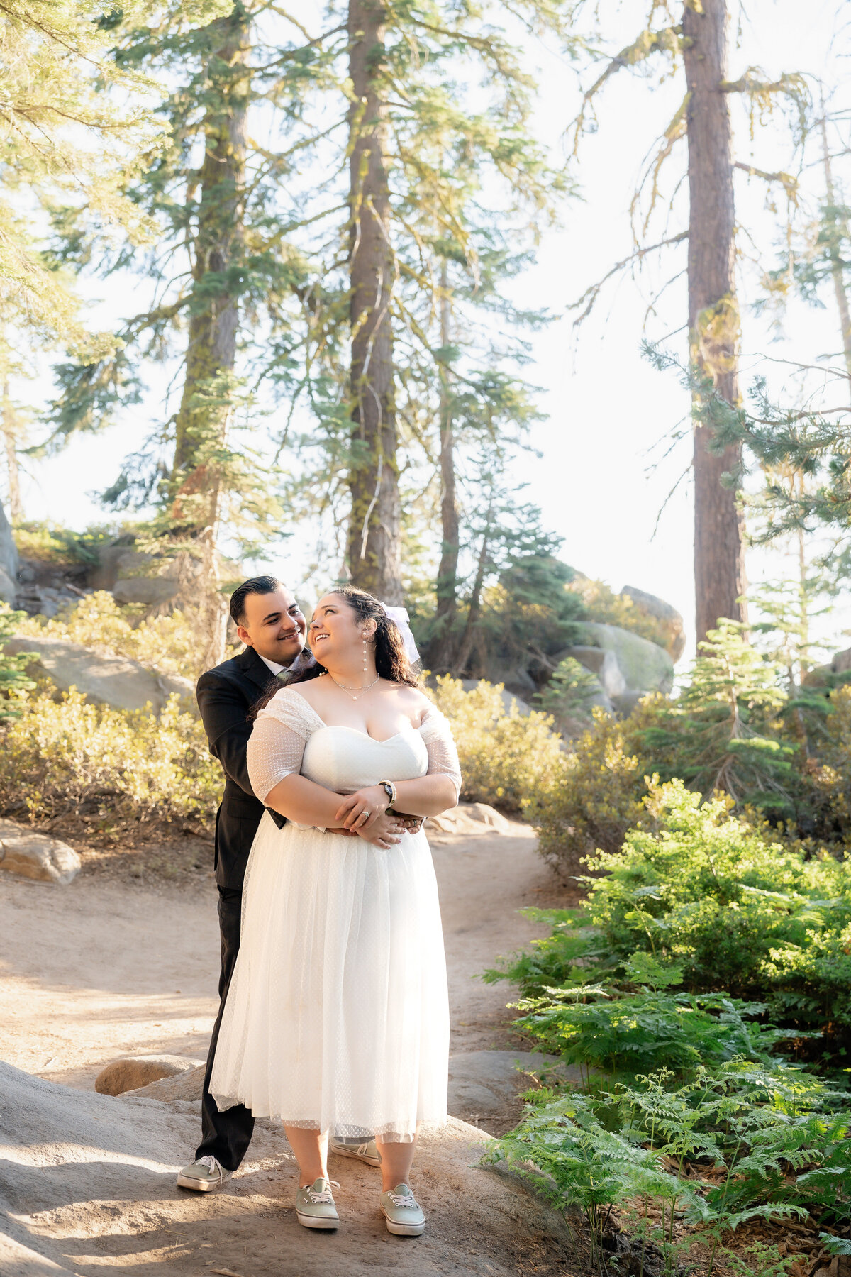 Bride and Groom eloping at Yosemite National Park Taft Point during summer with colorful wildflower lupines and golden glow forest trees.