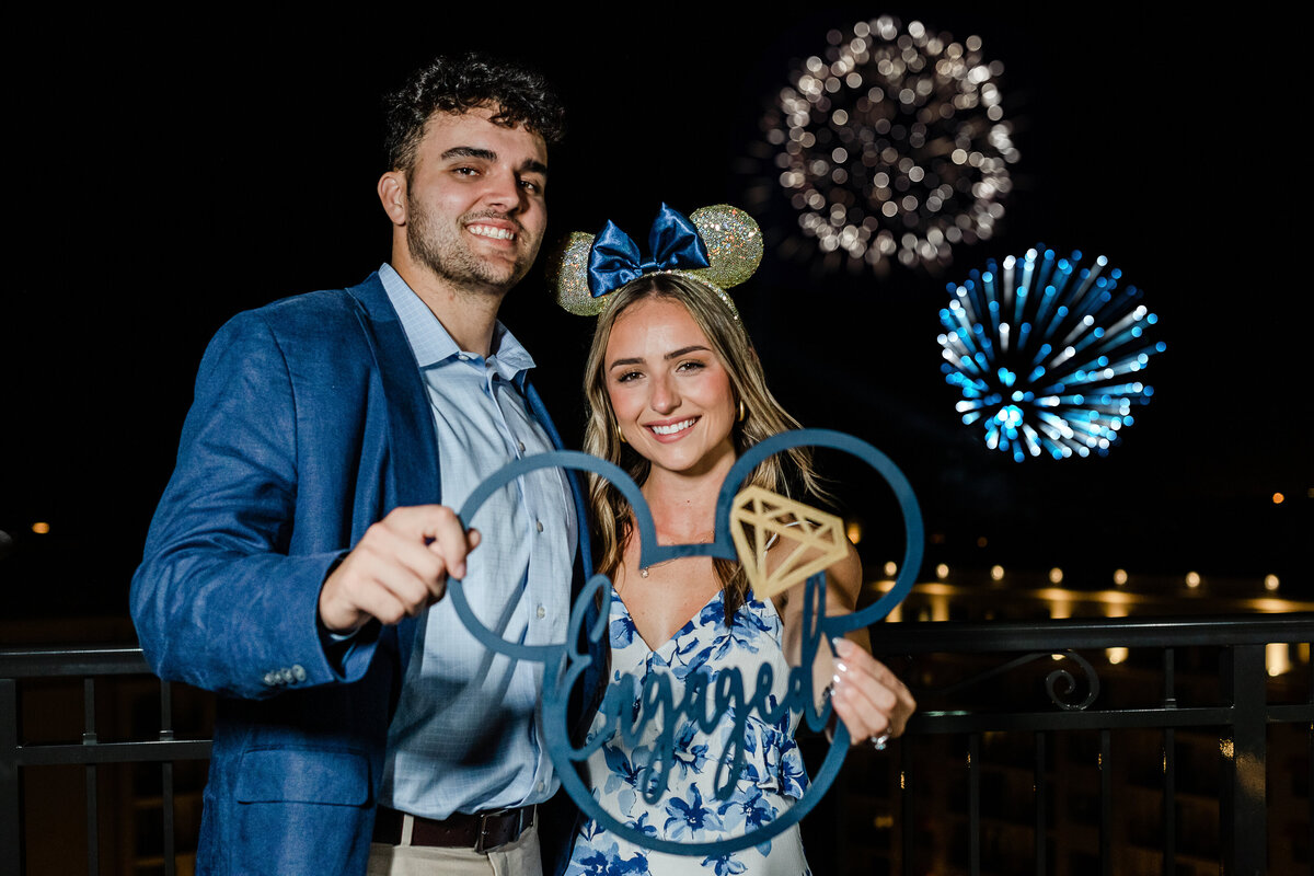 Newly engaged couple hold Micky  ears during Epcot fireworks at Disney's Riviera Resort