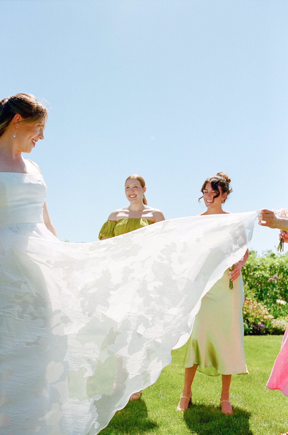 Bridesmaids fanning brides dress in the sunshine at The Orchard in Hood River