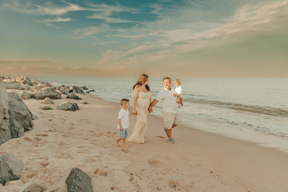 A family walking on the beach during a family session at Sandy Hook Beach in New Jersey.