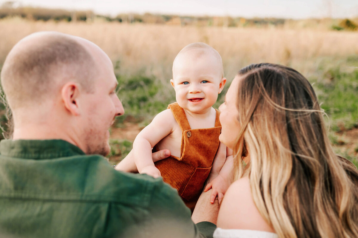 family photo of baby boy smiling with parents during Branson MO family photography session