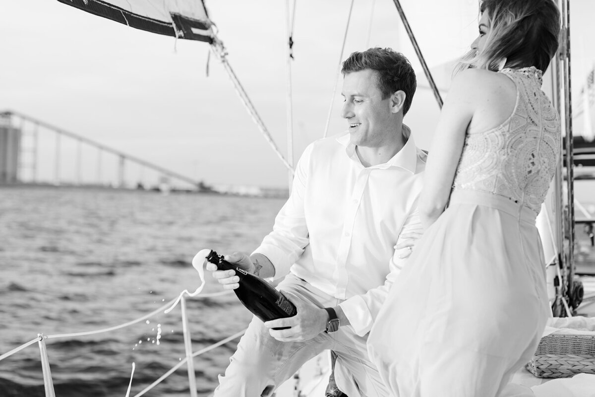 Couple popping champagne on a boat