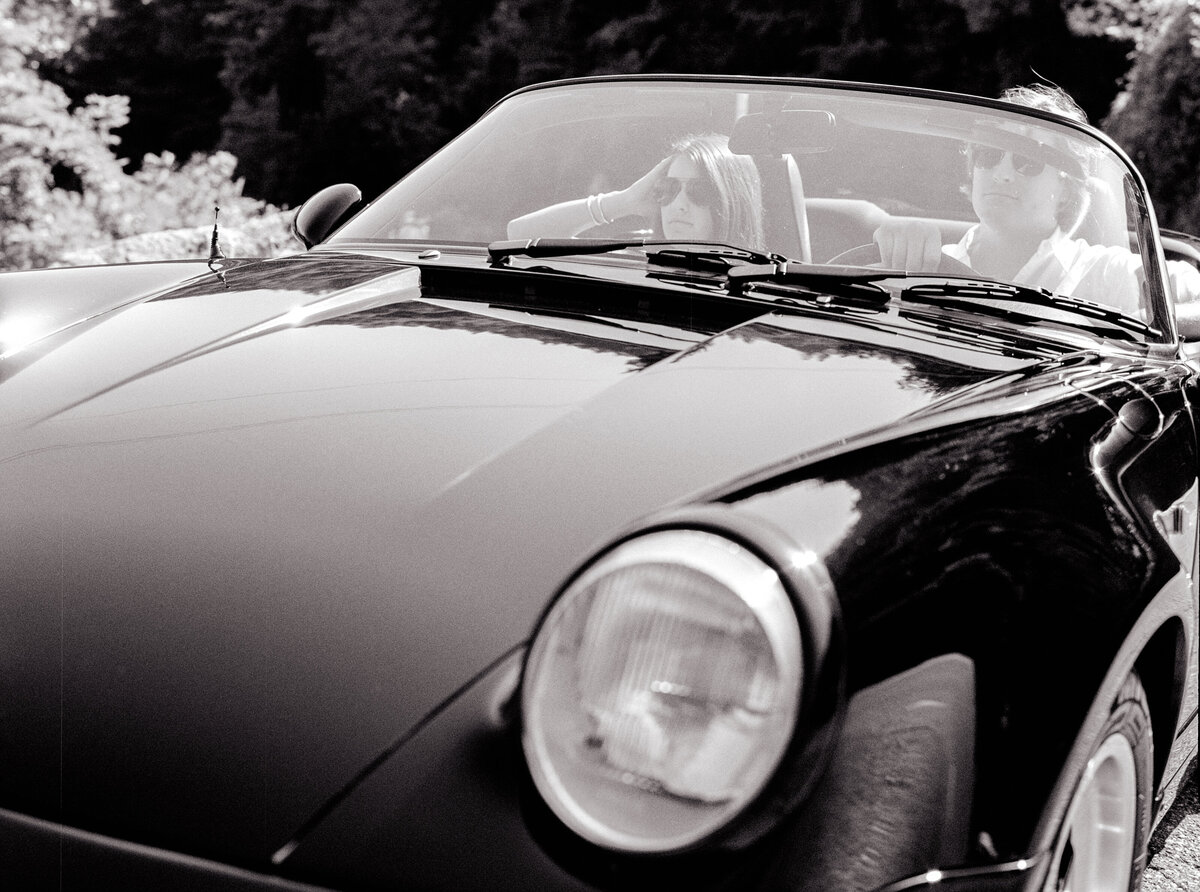 Black and white of couple in Porsche convertible during their Italy engagement session photographed by Italy wedding photographer