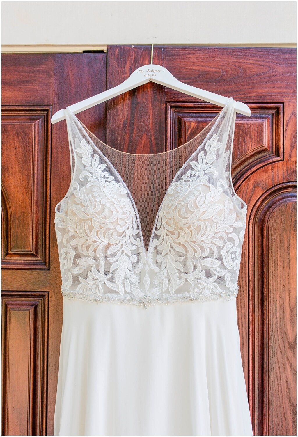 white dress hanging on door with lace