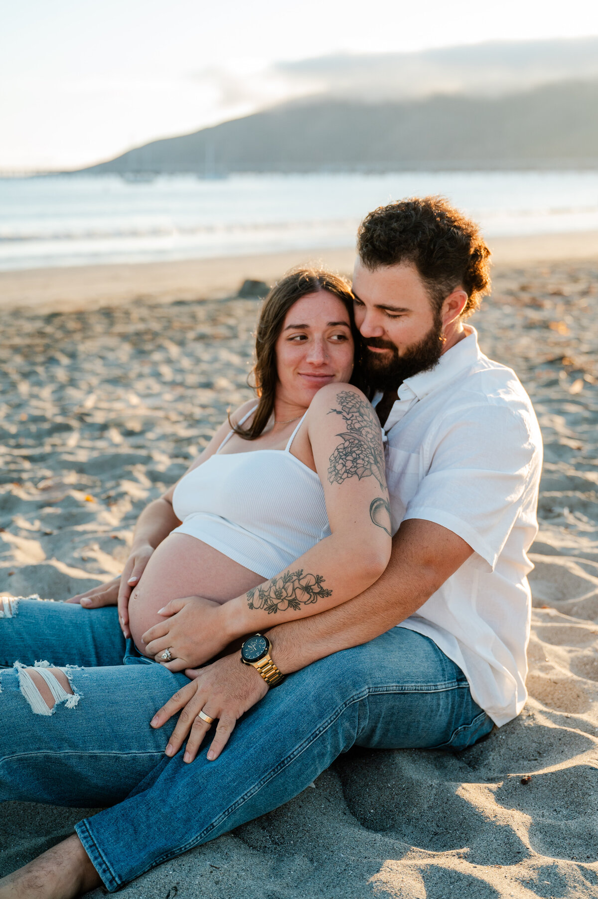 Maternity session at Avila Beach, with the expecting couple enjoying the coastal scenery and soft ocean light.
