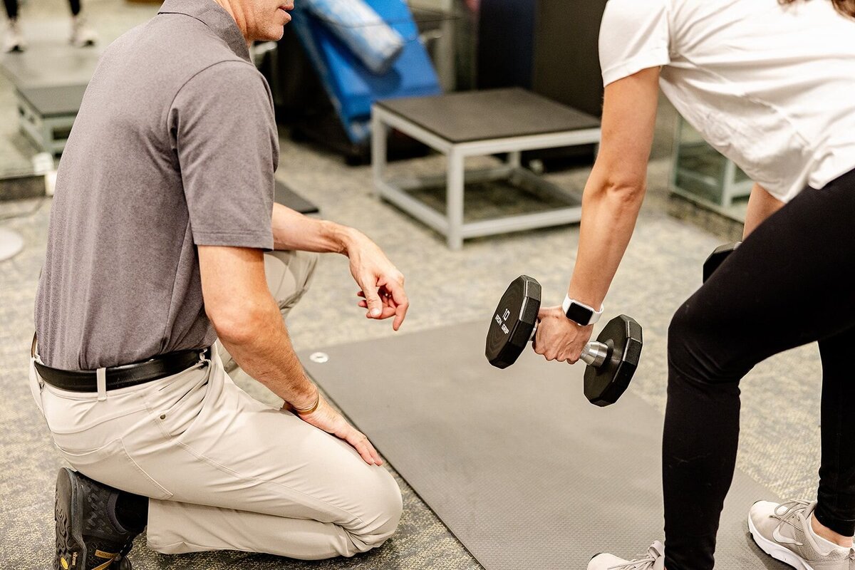 A person lifts weights with their Embody performance coach