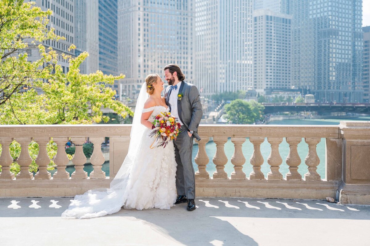 Bride and groom laughing at the Chicago Wrigley building.