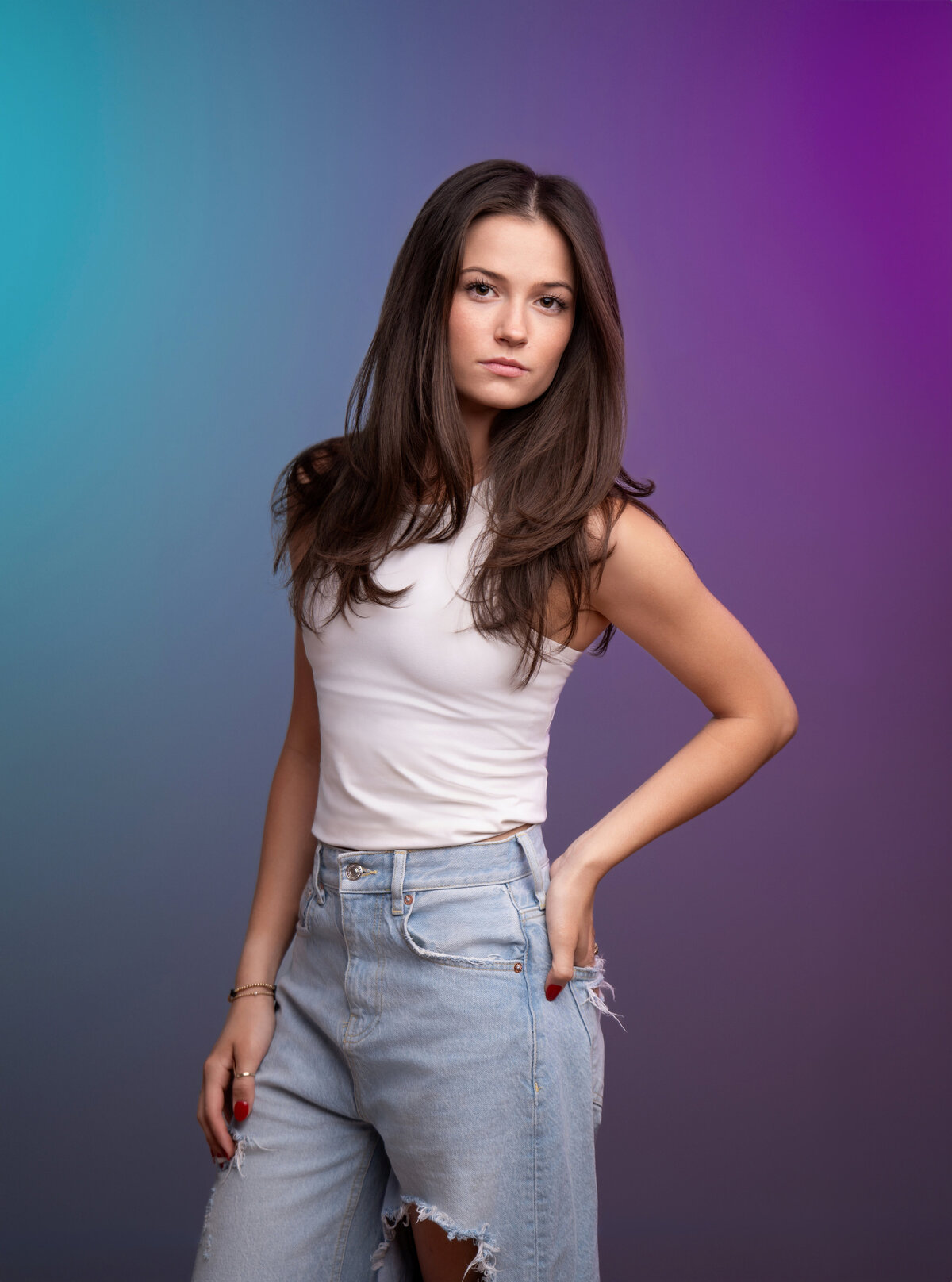Girl in casual outfit poses like a model for her senior portrait at a creative photography studio